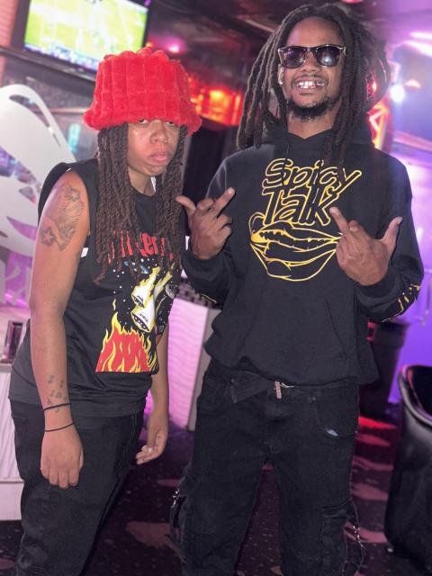 Slim VIP and LyricForever posing together while co-hosting a live event at Club Climaxxx, surrounded by colorful club lighting.